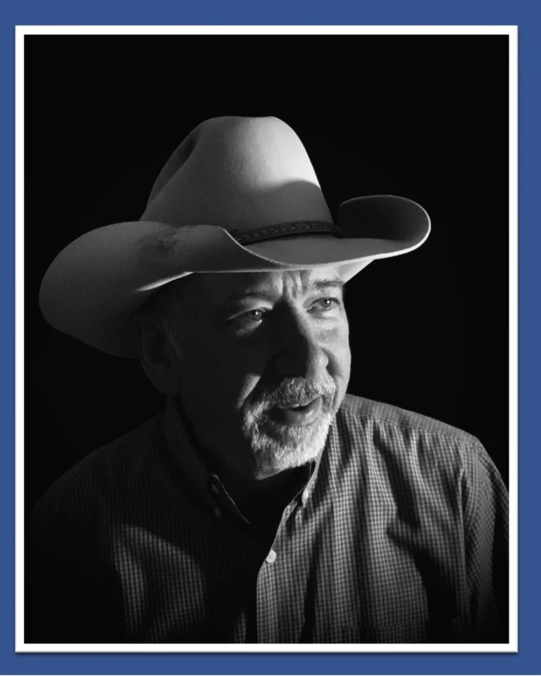 Black and White image of a cowboy in a cowboy hat in shadows.
